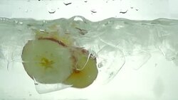 Apple slices drop in the ice water. Close up. Slow motion. Stock Footage