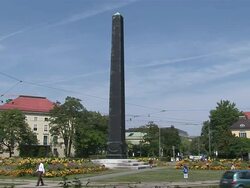 MS Shot of traffic moving and people walking infront of obelisk / Munich, Bavaria, Germany Stock Footage