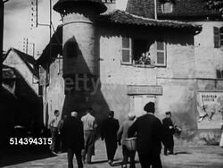 1950: BEAULIEU: DORDOGNE VALLEY:  VS Town crier Mr. Serus playing sneer drum on street, people gathering around, reading paper announcing forthcoming marriage (partial SOT), villagers listening. France, country, rural Instructional Video