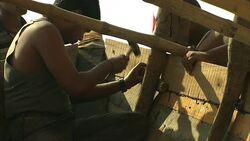A worker hammers a nail into the side of a wooden boat. Stock Footage