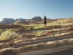 WS DS Rear view of man jogging in desert landscape / Lake Powell, Utah, USA Stock Footage