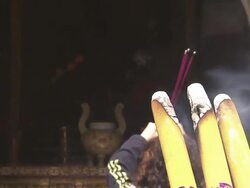 Incense burns in a temple as a monk bows and prays. Stock Footage