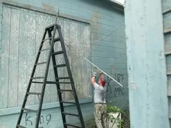 MS Volunteer Man working on rundown at vacant warehouse buildings in small town, breaking down fence / Rutland, Vermont, United States    Stock Footage