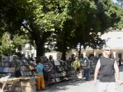 Books on Communism for sale in Plaza de Armas in center plaza of Havana Cuba with tourists Stock Footage
