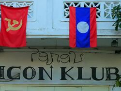 MS Shot of communist and Lao flag hanging on white balcony / Luang Prabang, Laos Stock Footage