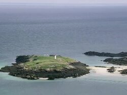 WS AERIAL ZO Shot of light house at Minques Rocky Islands / Jersey, Channel Isles Stock Footage