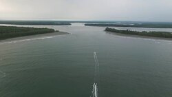 Small boats pass through the ocean entrance to the Murik Lakes Stock Footage