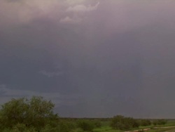 Bright, curved bolt of forked lightning strikes ground from daytime Arizona monsoon thunderstorm, USA Stock Footage