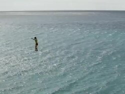 Athlete balances along highline stretched above creek, old town Stock Footage