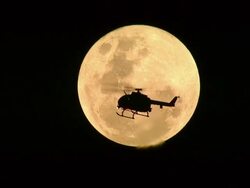 WS AERIAL View of Helicopter silhouetted against bright moon at night / Rustenburg, North West Province, South Africa Stock Footage