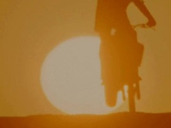 MS SLO MO Shot of Motorcyclists jumping over sand dunes Stock Footage