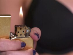 CU TU R/F SLO MO Shot of Latin middle eastern female with lighter, lifting it to cigarette / Studio, New York, United States Stock Footage