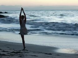 MS Ballerina dancer in white swan costume dancing on beach beside ocean at sun rises / Montezuma, Nicoya Peninsula, Costa Rica Stock Footage