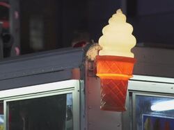 A parked ice cream truck in Time Square.  A plastic Ice Cream lamp is lit on the corner of the truck. Stock Footage