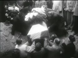 B/W 1956 people lower flag + lower covered coffin into large hole / Hungarian uprising Stock Footage