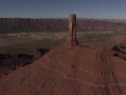 Wide Shot aerial - A sandstone pillar tops a mesa in Monument Valley / Monument Valley, Utah, USA Stock Footage