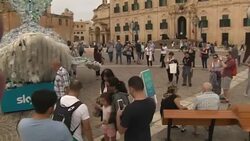 Tourists looking at Plasticus, the Sky Ocean Rescue mascot in Valletta News Clip