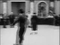 B/W 1916 Charlie Chaplin as Little Tramp roller skating + colliding with other man Stock Footage