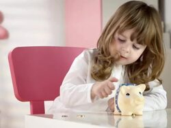 HD DOLLY: Little Girl Putting Coins Into A Piggy Bank Stock Footage