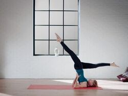 Woman practicing yoga in gym (shoulder stand and plough pose) Stock Footage