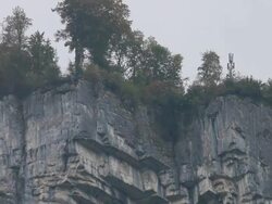 BASE jumper/wing suit flier descends from cliff Stock Footage