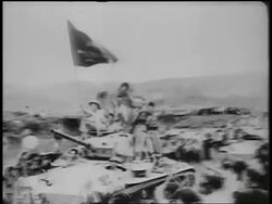 B/W 1950s PAN soldiers waving + holding flag riding tank in military parade / North Vietnam Stock Footage