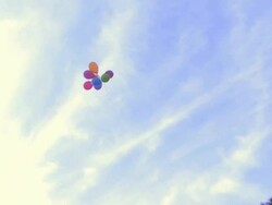 Woman releasing balloons into the air; UK Stock Footage