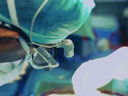 Surgeon leans over patient during operation Stock Footage