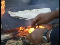 CU Bedouin man, preparing food around fire in desert, Egypt Stock Footage