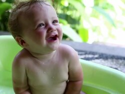 CU Shot of mother washing her baby son in bathtub and baby smiling / Ubud, Bali, Indonesia Stock Footage