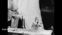 1934: ABOARD CRUISE SHIP: HD: MS Bartender body shaking cocktail drink, MS Mixed drink being poured from shaker into cocktail glass, party of four people dressed in black tie & gowns drinking cocktails at table, legs of couples dancing, more ocean. Instructional Video