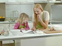 HD DOLLY: Mother And Daughter Looking In A Cookbook Stock Footage