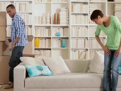 Couple moving boxes and sitting on sofa Stock Footage