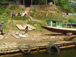 MS PAN SLO MO Shot of boats along river bank and people moving on stairs / Nong Khio, Luang Prabang, Laos Stock Footage
