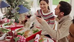 Couple toasting wine glasses at Christmas dinner table with family Stock Footage