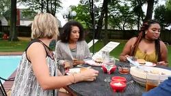 MS PAN Smiling group of friends sitting down with food at outdoor table in backyard on summer evening Stock Footage