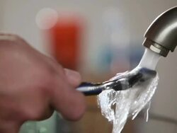 CU Rinsing off Razor in sink / Los Angeles, California, United States Stock Footage