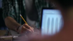 Wood shop craftsmen write with pencil and paper and work on laptop Stock Footage