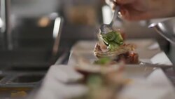 Restaurant chef garnishes gourmet lobster dish in restaurant kitchen Stock Footage