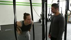 Woman athlete using the gymnastic rings with her trainer Stock Footage