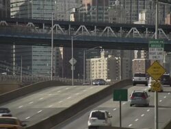 Traffic speeds down the FDR Highway in New York City.  Two subway trains cross the Manhattan Bridge at the same time. Stock Footage