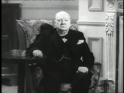 Winston Churchill sits in a chair. News Clip