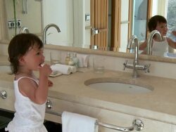 MS Shot of little metis girl is brushing her teeth in bathroom / Marbella, Andalusia, Spain Stock Footage