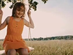 Young girl having fun swinging on a tree swing Stock Footage