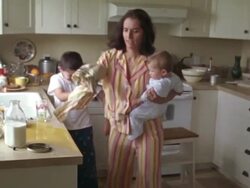 MS Mother helping son clean spilled juice on kitchen counter while holding baby / Washington State, USA Stock Footage