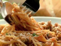 fork twirls spaghetti noodles into spoon from pasta marinara dish served on a plate  Stock Footage