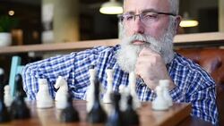 an elderly man playing with himself in chess Stock Footage