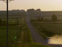 Slow motion static view of car driving down dirt road. Stock Footage