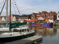 WS View of boats on harbor and old town with people moving on street, North Sea North Frisia, / Husum, Schleswig Holstein, Germany Stock Footage