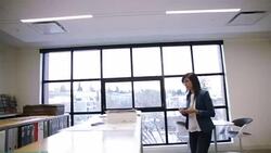 Architect entering office with cell phone and reviewing paperwork at counter Stock Footage